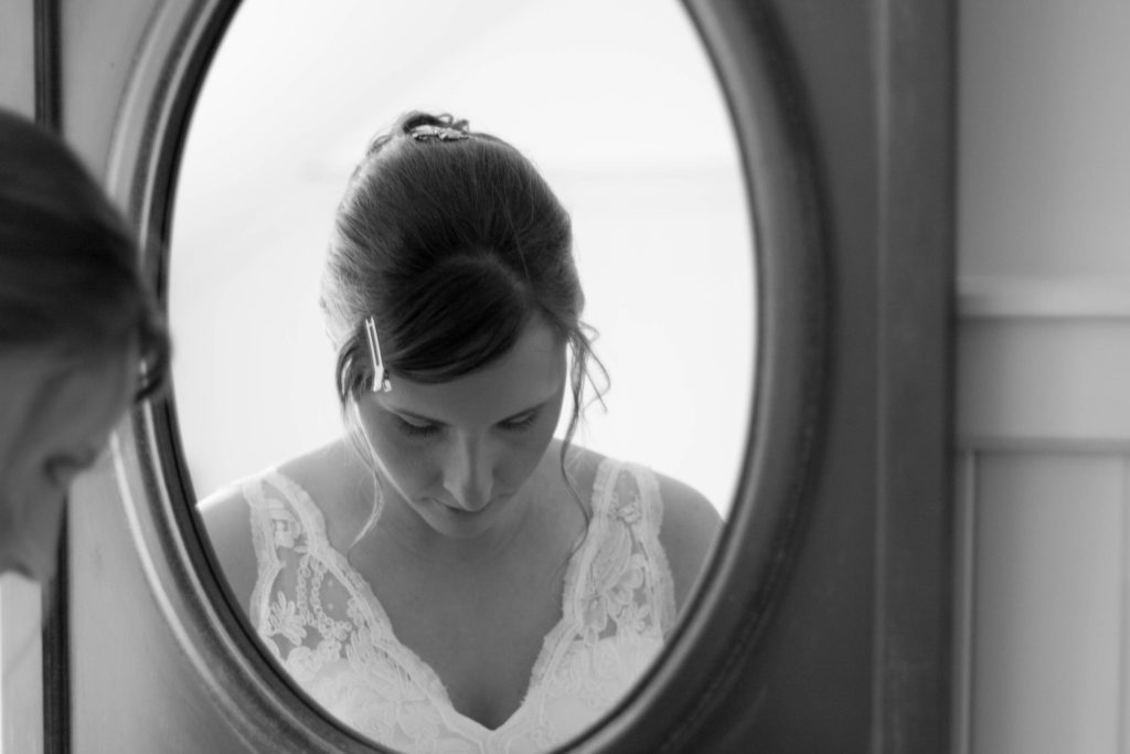 elope to ireland bride looking down whilst beside the mirror