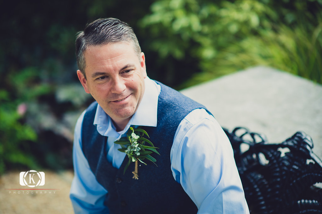 Elope to Ireland elopement in dublin ireland on a cliff groom siting on a bench before the ceremony