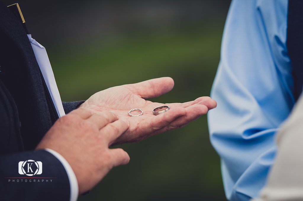 Elope to Ireland in dublin on a cliff at the Howth lighthouse walk bride and groom having their ceremony with rings
