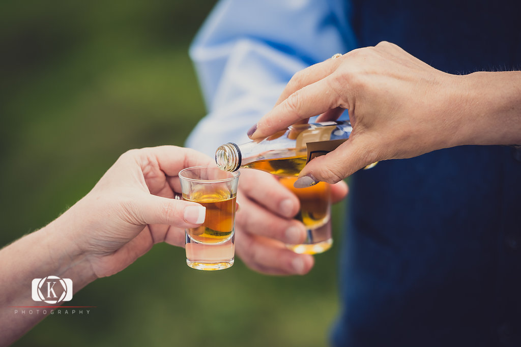 Elope to Ireland in dublin on a cliff at the Howth lighthouse walk bride and groom ceremony having a wee whiskey