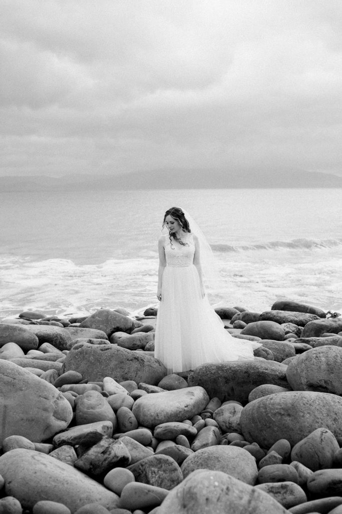 The bride beside the coast in her wedding dress in black and white 