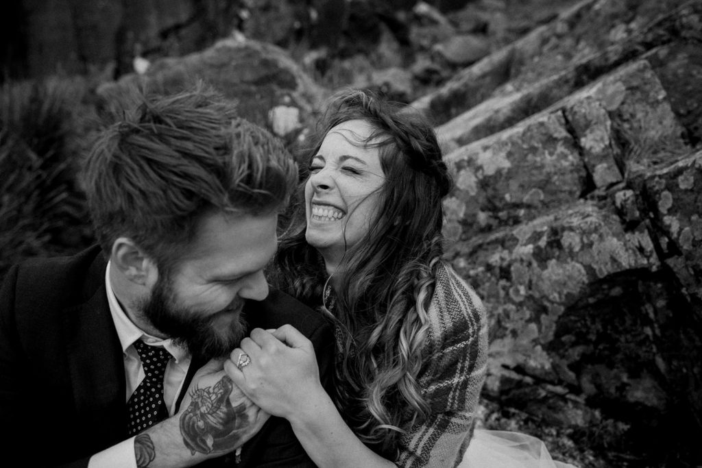 A black and white image of the couple laughing at their Coastal intimate Wedding in Ireland. 