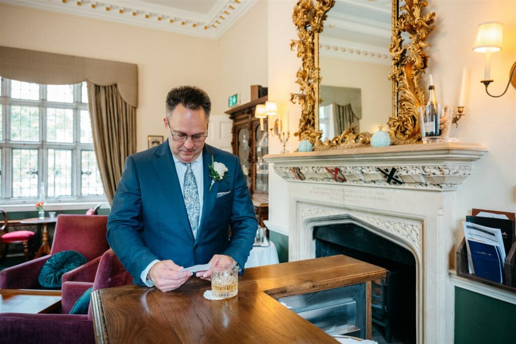 Elope To Ireland elegant wedding at Waterford castle groom reading love note 