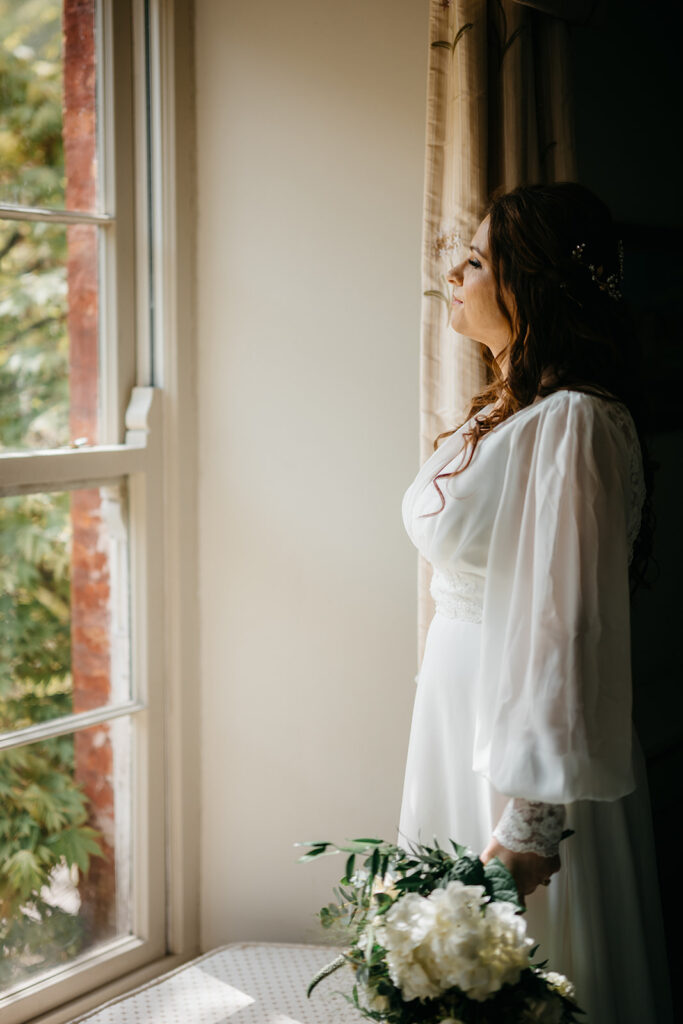 An Elegant Spring Elopement in West Cork at Bantry House - bride looking over Bantry bay from her window in bantry house 