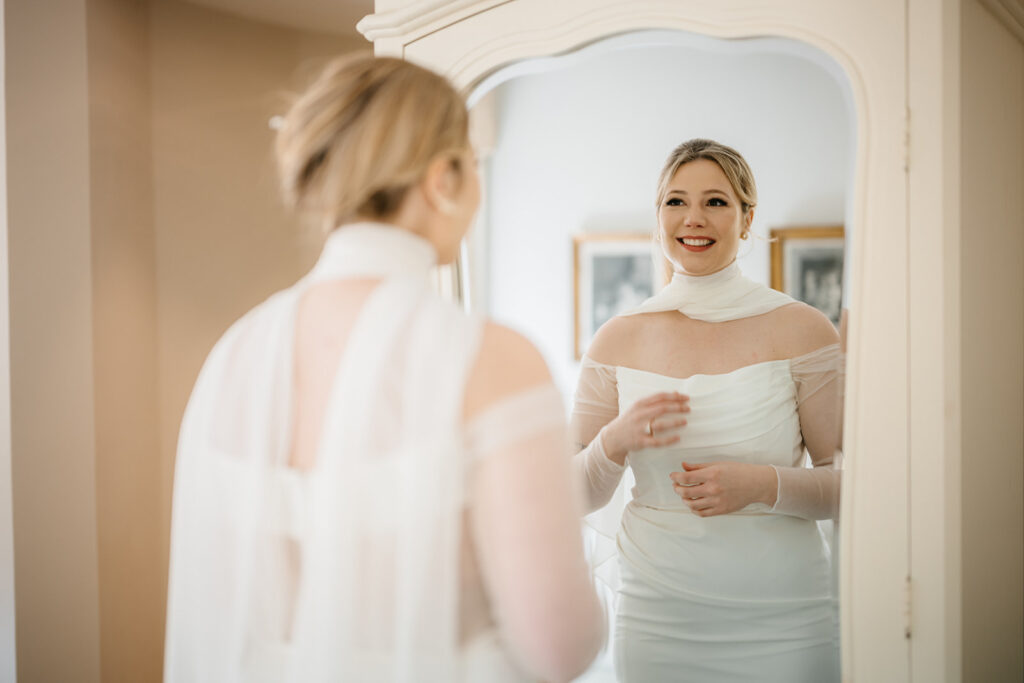  bride smiling in front of the mirror enjoying the day before her Elegant Spring Elopement in West Cork at Bantry House 