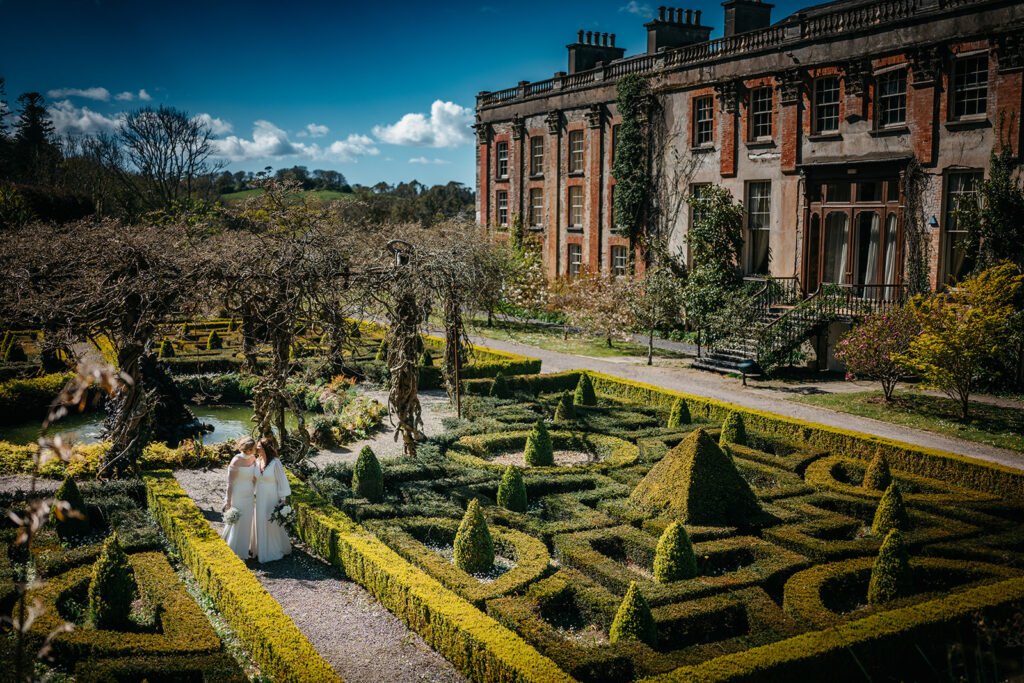 beautiful west Cork wedding ceremony at Bantry House brides sitting close together in bantry house garden 