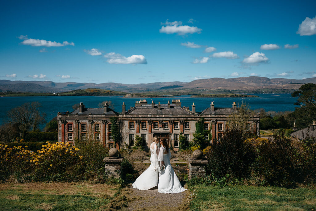 beautiful west Cork wedding ceremony at Bantry House brides sitting close together in bantry house garden 