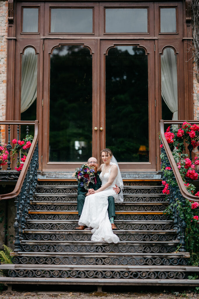  The Perfect Elopement for a New Brunswick Couple sitting out the window at Bantry house with red flowers either side 