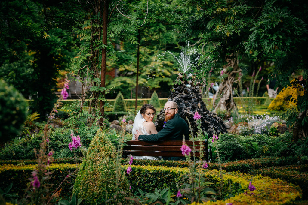 Just married couiple lookiing over their shoulders at the cameraman