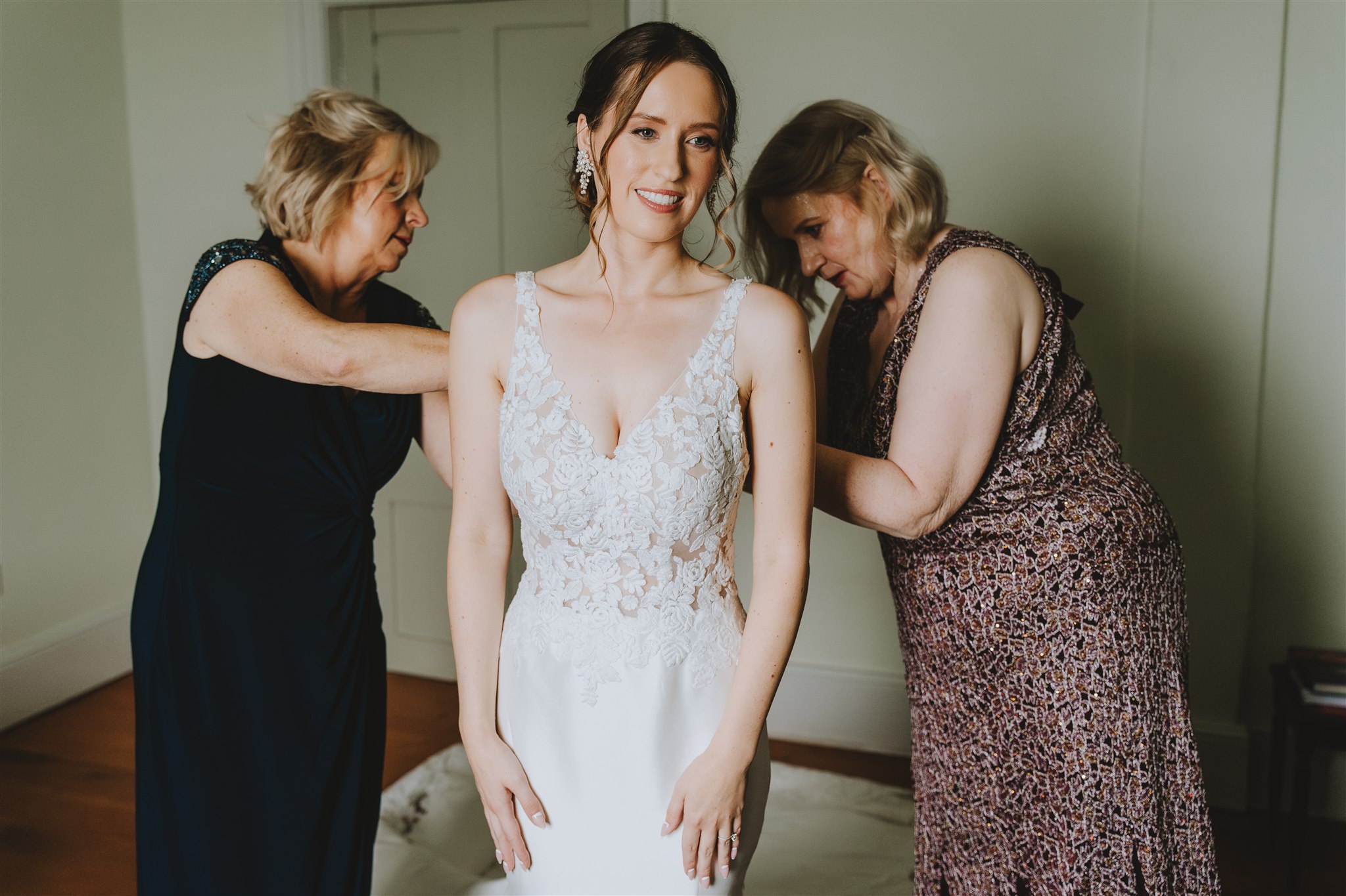 bride being helped with her friends getting into her dress