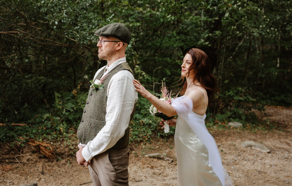 the bride taps the groomon the shoulder before the fisrst look