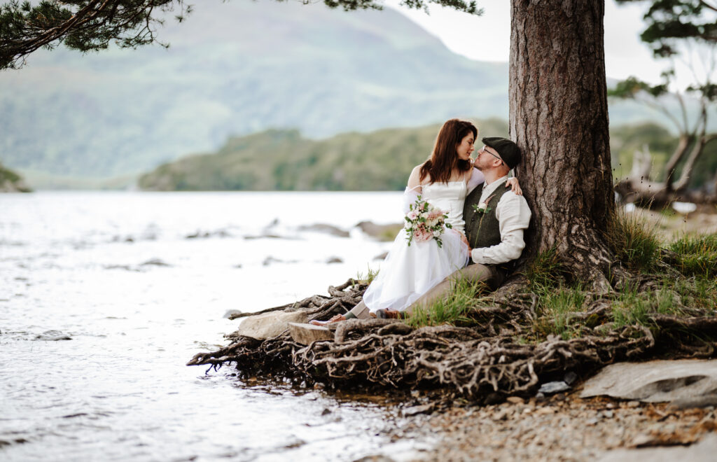Just married embracing under a tree in Killarney national park 