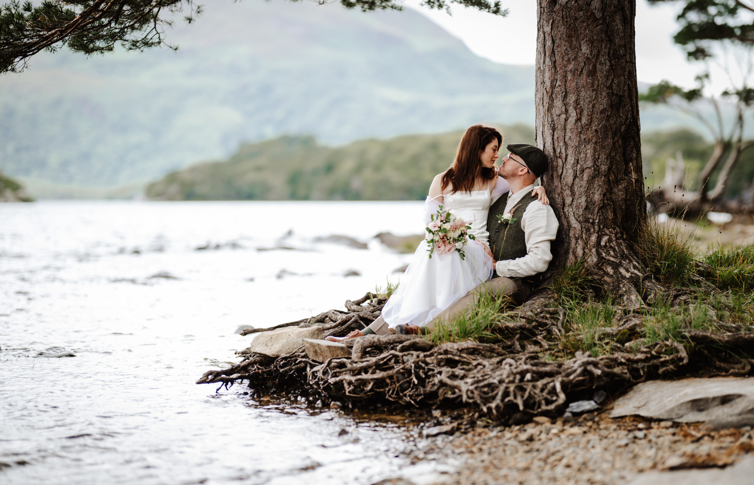 Just married embracing under a tree in Killarney national park