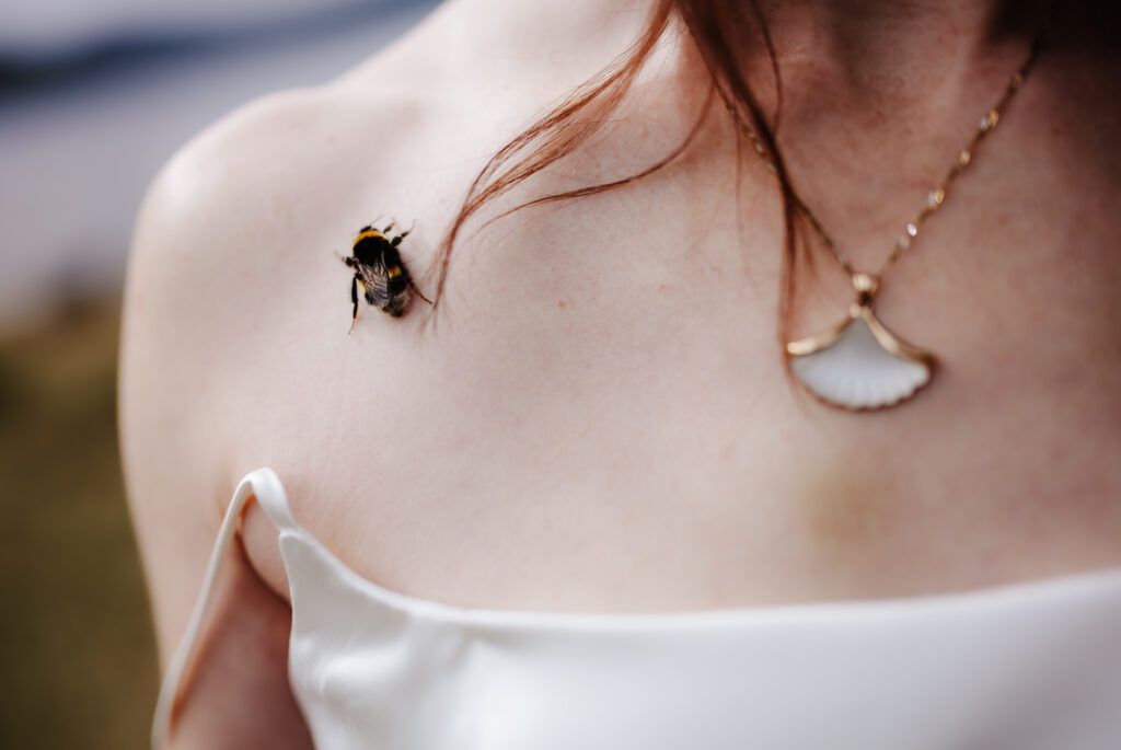 a bee settles on the brides shoulder