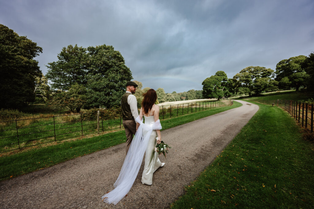 bride and groom walking down a country path 